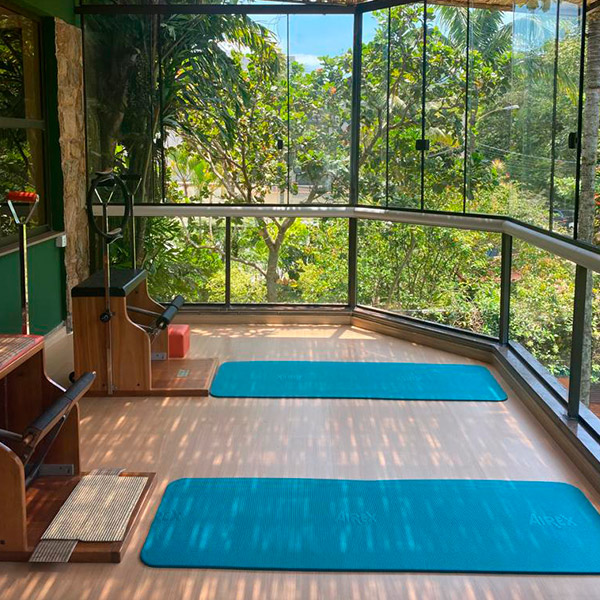 Sala principal do estúdio KASA com mats azuis e vista para o jardim